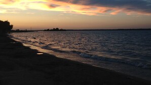 Una playa con vista al mar y una costa lejana.