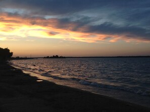 Una platja amb vista al mar i una línia de costa llunyana.