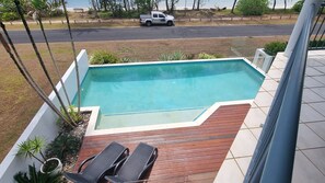 A rectangular swimming pool with a wooden deck and two lounge chairs. - Salt on South- Beach front views (South Mission Beach)
