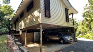 A two-story house with a covered garage and a car parked inside.