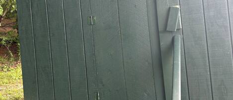 A green wooden door with a circular moon and sun decoration.