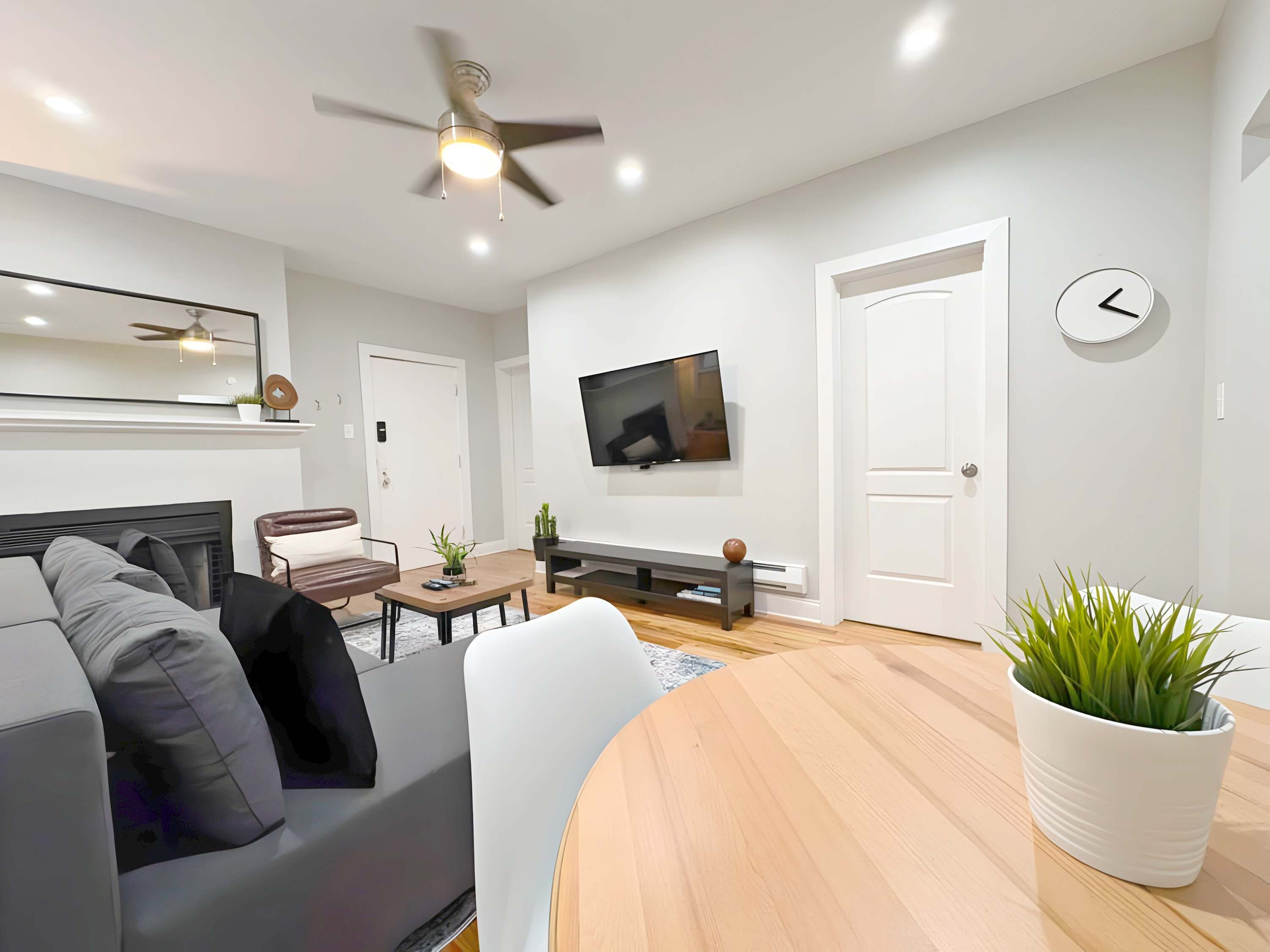 A modern living room with a sofa, a coffee table, a TV, and a dining table.