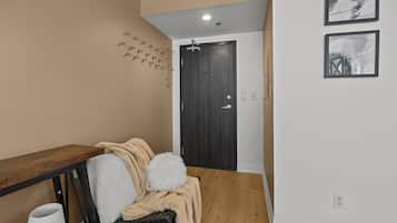 A hallway with a wooden bench, a door, and two framed pictures on the wall.