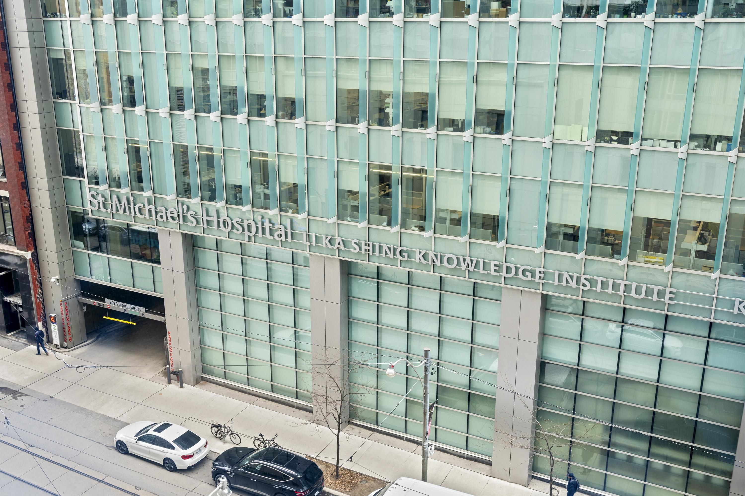 A modern building with large glass windows and a sign for St. Michael's Hospital and the Knowledge Institute.