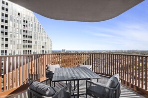A balcony with a table and chairs, overlooking a cityscape. - Skyline 3-Bed Apartment Near South Melbourne (South Melbourne)
