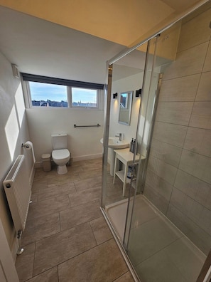 A modern bathroom with a toilet, sink, and shower area. - Market Quarter, town centre. free parking & wifi (Southport)