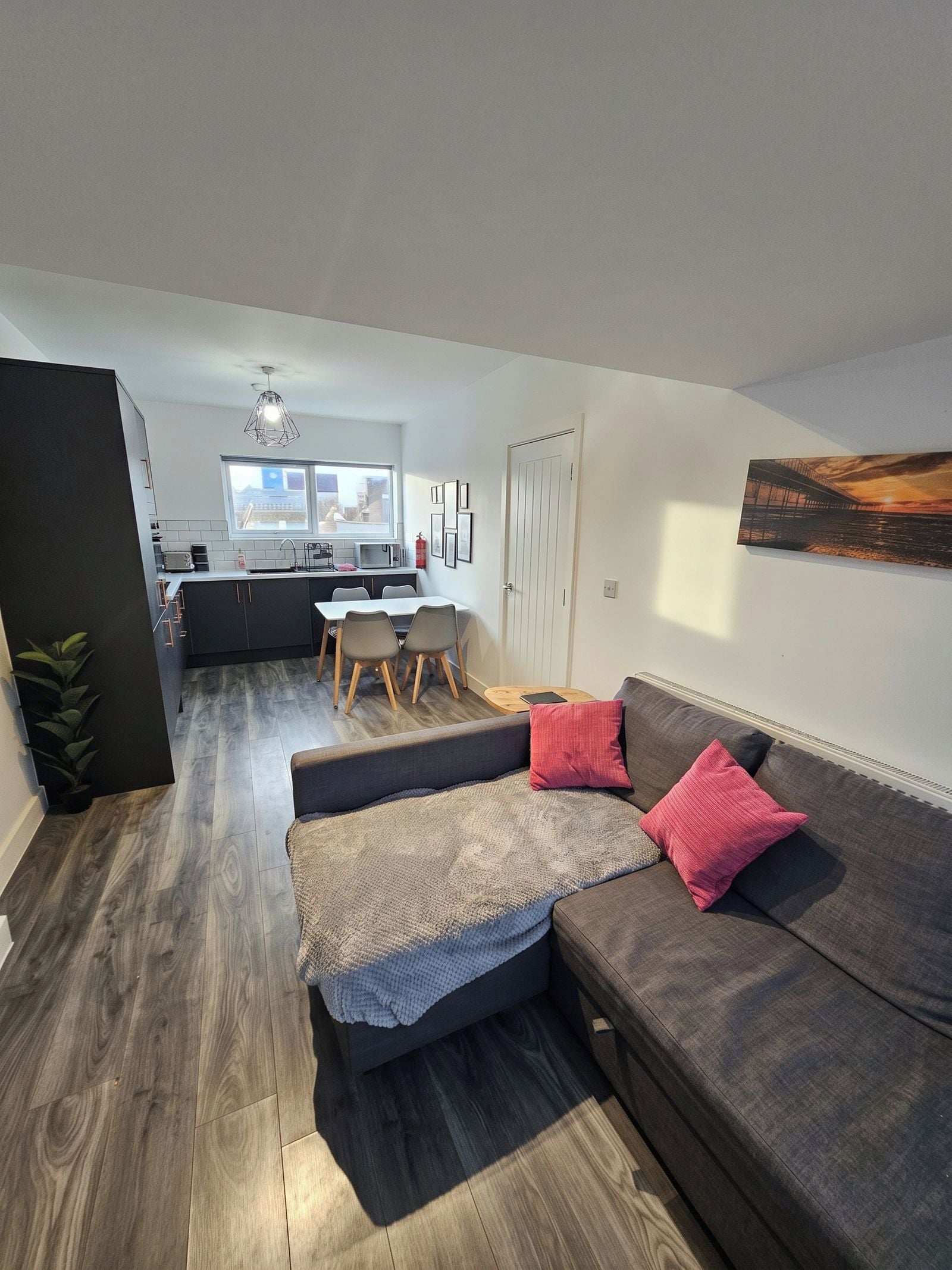 A modern apartment with a living area, kitchen, and dining space.
