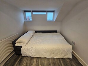 A bedroom with a bed, a window, and a radiator. - Market Quarter, town centre. free parking & wifi (Southport)