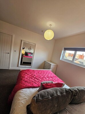 A bedroom with a bed, a dresser, a mirror, and a window. - Market Quarter, town centre. free parking & wifi (Southport)