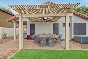 A patio with a pergola, outdoor table, and chairs. - Scottsdale Retreat Private Hot Tub (Scottsdale)