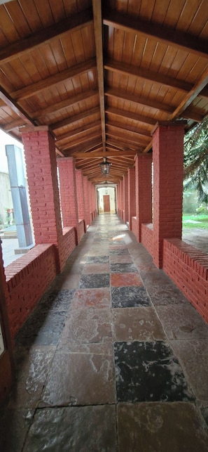 A covered corridor with red brick walls and a tiled floor. - Elegant apartment in La Recoleta. (Buenos Aires)