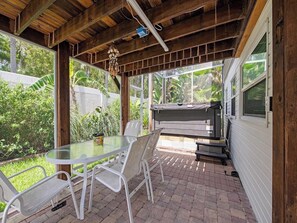 Una terrazza all'aperto con tavolo e sedie in vetro, un barbecue e vista sul verde.