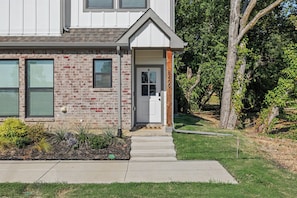 A two-story house with a brick facade, a front door, and a small porch. - Dallas–McKinney Luxury Retreat  5BR + Game Room (McKinney)