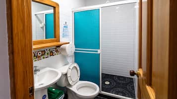 Un baño con inodoro, lavamanos y ducha.