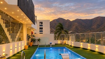Un bâtiment moderne doté d’une piscine, d’un escalier et offrant une vue sur les montagnes.