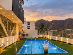 A modern building with a pool, stairs, and a view of mountains. - Hotel Casa Romana Rodadero (Santa Marta)