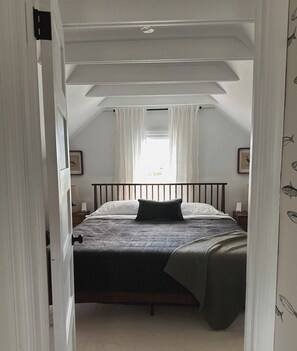Un dormitorio con cama, una ventana con cortinas, una puerta y una pared con motivo de peces.