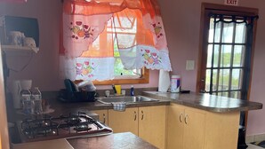 A kitchen with a gas stove, sink, and wooden cabinets. - perfect for family. Angler and nature guides (Queens highway)