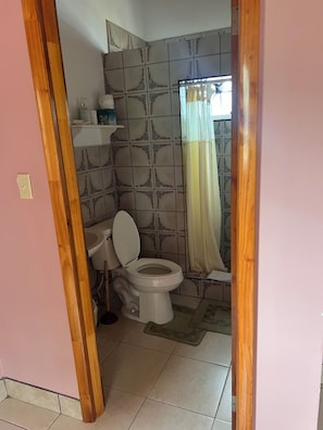 Ein Badezimmer mit Toilette, Waschbecken und Duschbereich.