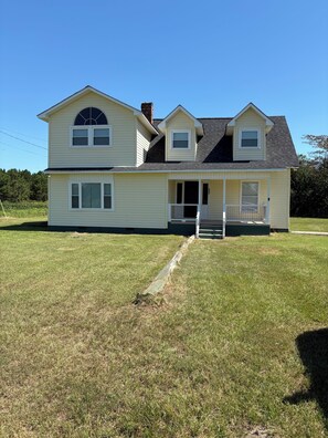 A two-story house with a front porch, a covered entryway, and a large front yard. - Spacious 4-bedroom house with AC in welcoming Santee. Your Home Away from Home! (Santee)