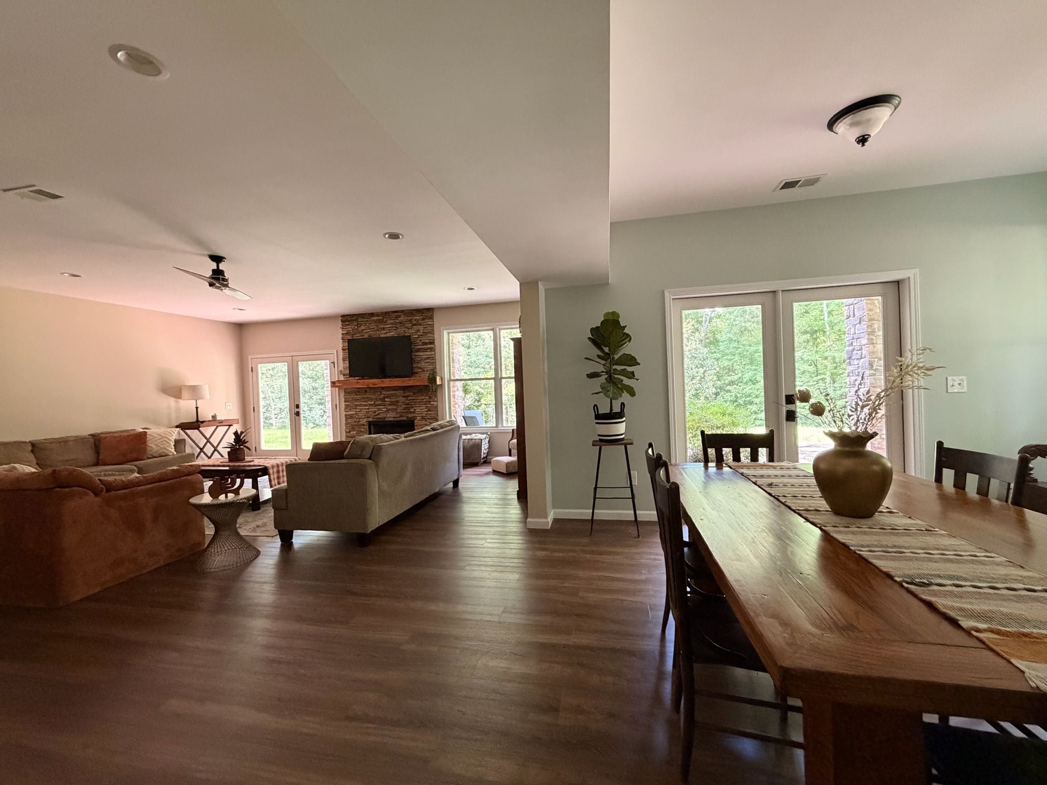A spacious living area with a wooden dining table, a sofa, and a fireplace.