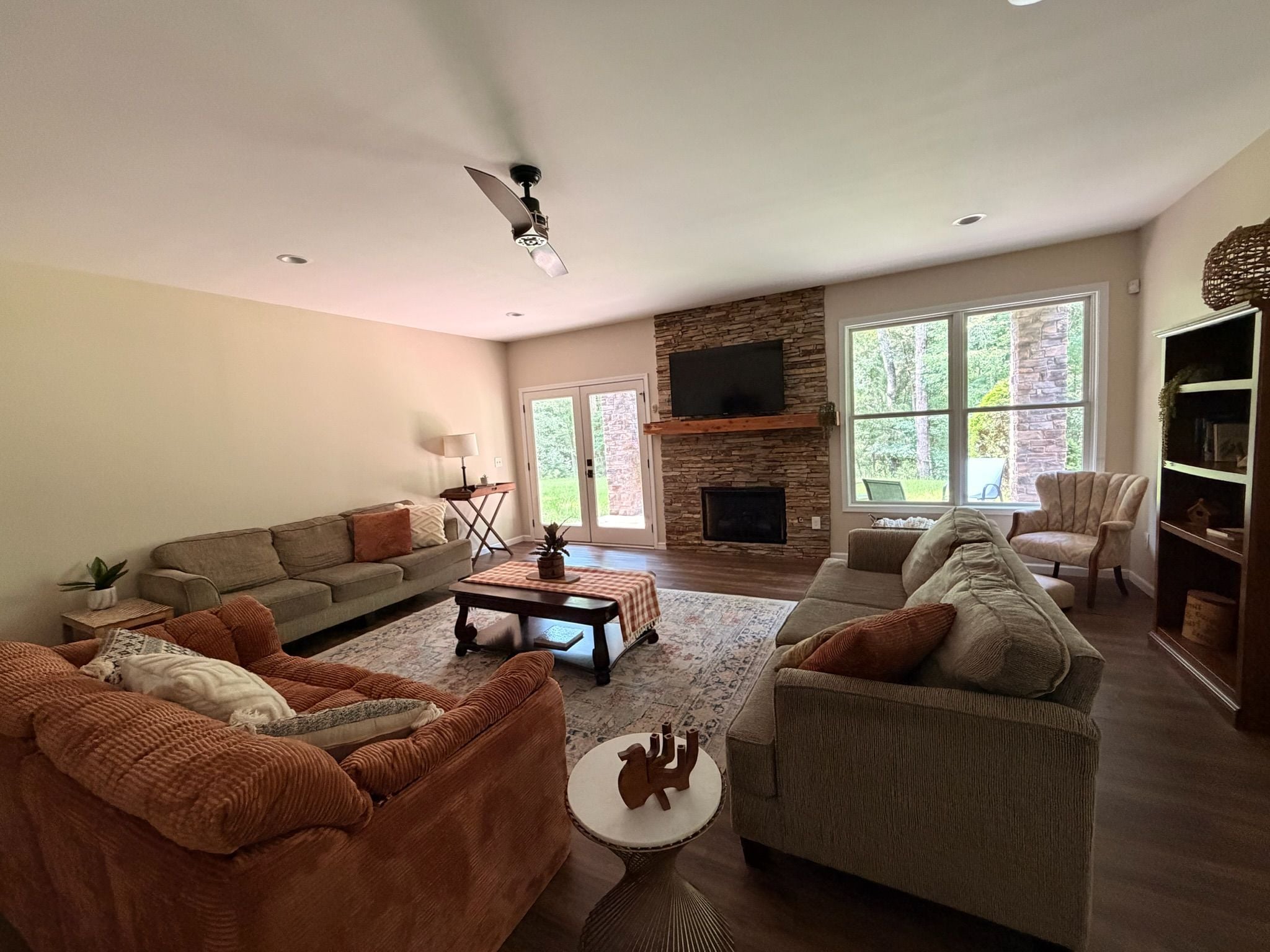 A spacious living room with a fireplace, two sofas, a coffee table, and a television.