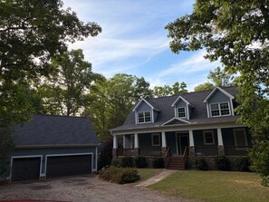 A two-story house with a garage, a front porch, and a well-maintained lawn.