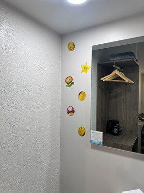 A bathroom with a mirror, a hanging wooden hanger, and a coffee maker on the counter. - Spacious 2 Queen Beds, Pool, Prime Kissimmee Location (Kissimmee)