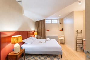 A modern hotel room with a bed, bedside lamp, and a view of the city. - Le Charme Chavannes - Welkeys (Paris)