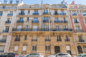 A multi-story building with ornate balconies and large windows. - Le Charme Chavannes - Welkeys (Paris)