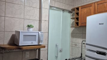 A compact kitchen with a microwave, stove, and cabinets.