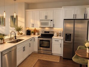 A modern kitchen with stainless steel appliances, white cabinetry, and a central island. - Private 3B 3B- Pool Townhome Near Disney - Family Getaway (Kissimmee)