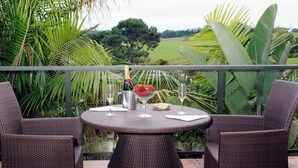 A round table with two wicker chairs on a balcony overlooking a green landscape. - O'Grady Lodge - The Whole Wing (Wainui)