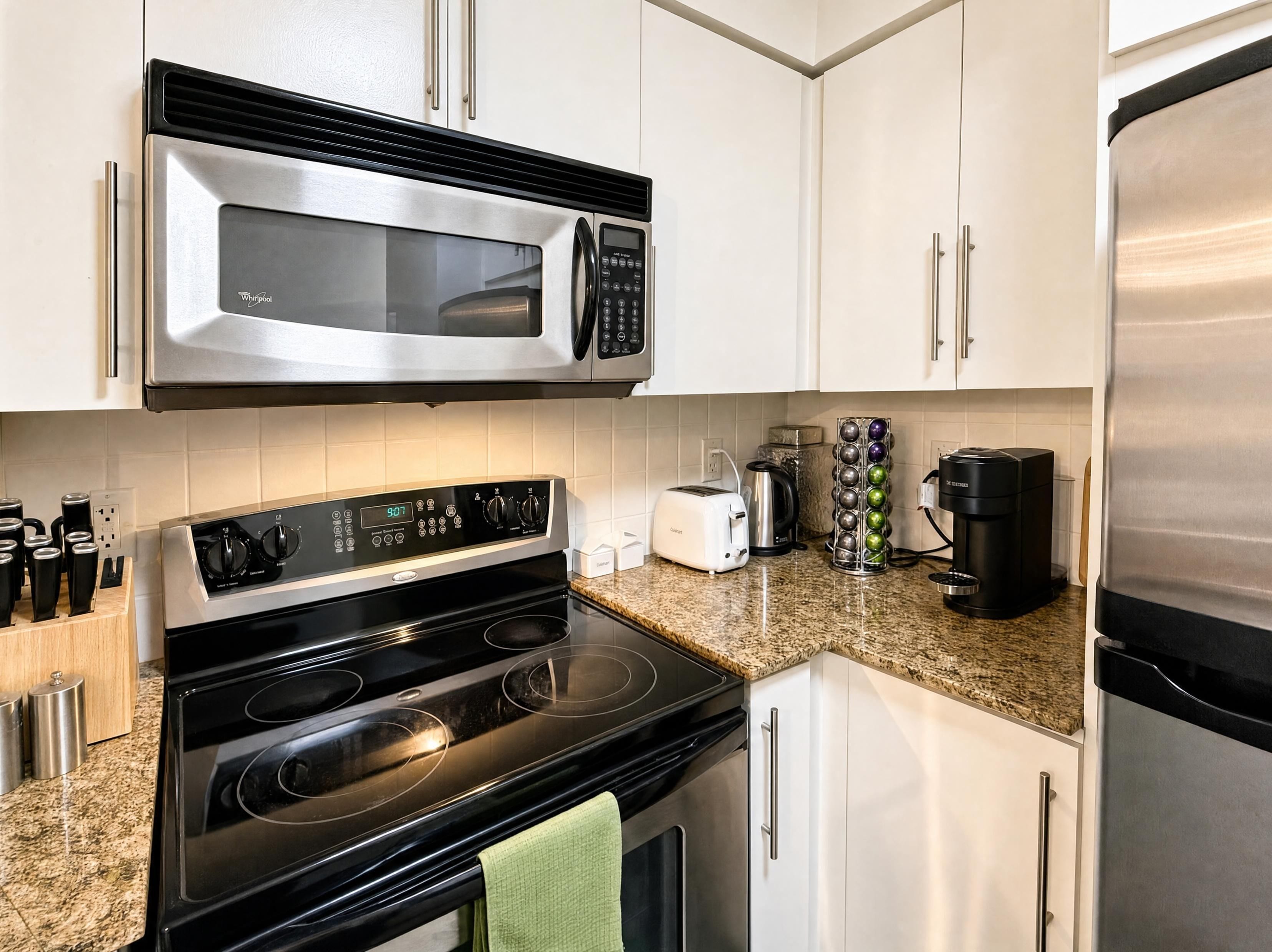 Una cocina moderna con electrodomésticos de acero inoxidable, incluyendo un microondas, estufa y refrigerador.
