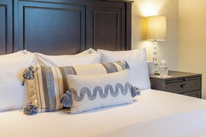 A neatly made bed with multiple pillows, a bedside lamp, and a nightstand with a glass container. - Casa Lomboy - Cabo del Sol | 6 Bed, 6.5 Bath (Cabo San Lucas)