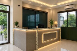 A reception desk with a 'RECEPTION' sign, a ceiling fan, and an air conditioning unit. - Classic Wardha Road Nagpur (Nagpur)