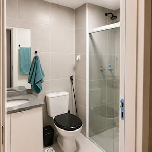 A bathroom with a toilet, a shower enclosure, and a sink. - Vrbo Property (Rio de Janeiro)