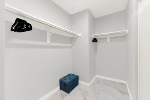 A walk-in closet with white shelving units, a blue storage bench, and hanging clothes racks. - New! Luxury Spacious Home 4 Beds 2 Bath 20 Min DTX (Balch Springs)