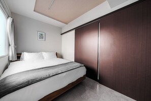 Ein Schlafzimmer mit einem Bett, einem Kleiderschrank und einem gerahmten Bild an der Wand.