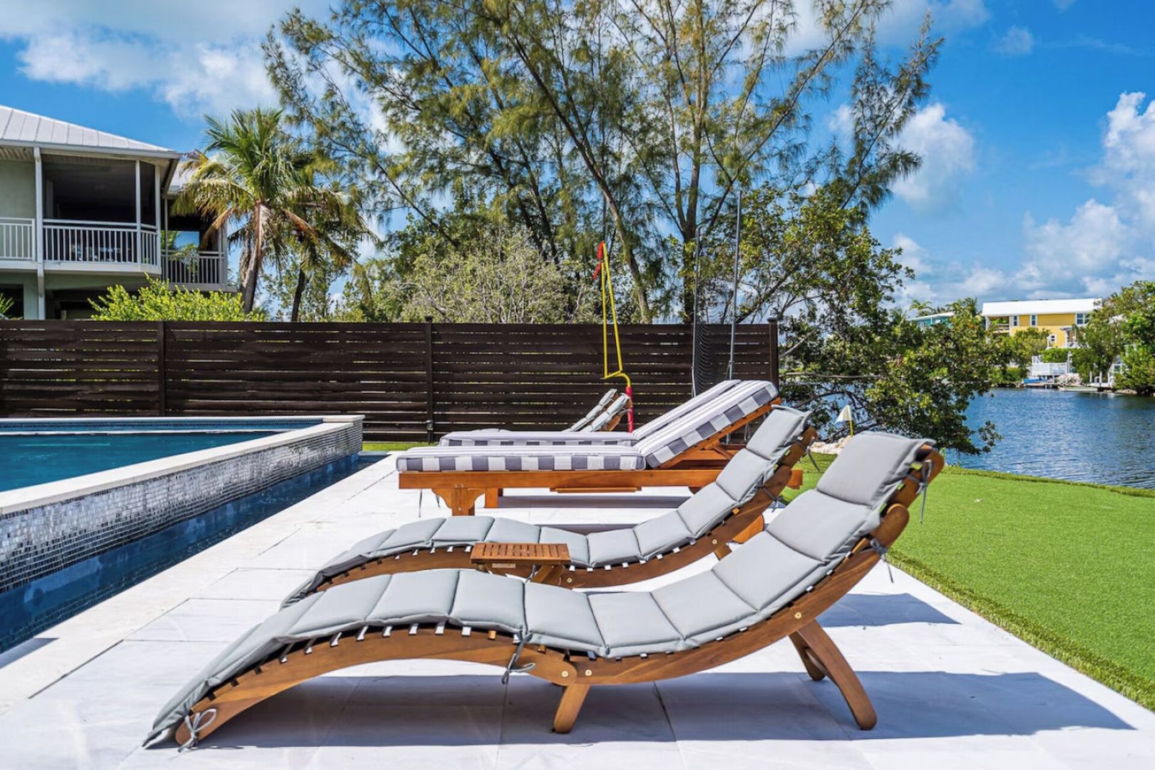 Un área junto a la piscina con sillones de descanso y un jacuzzi.