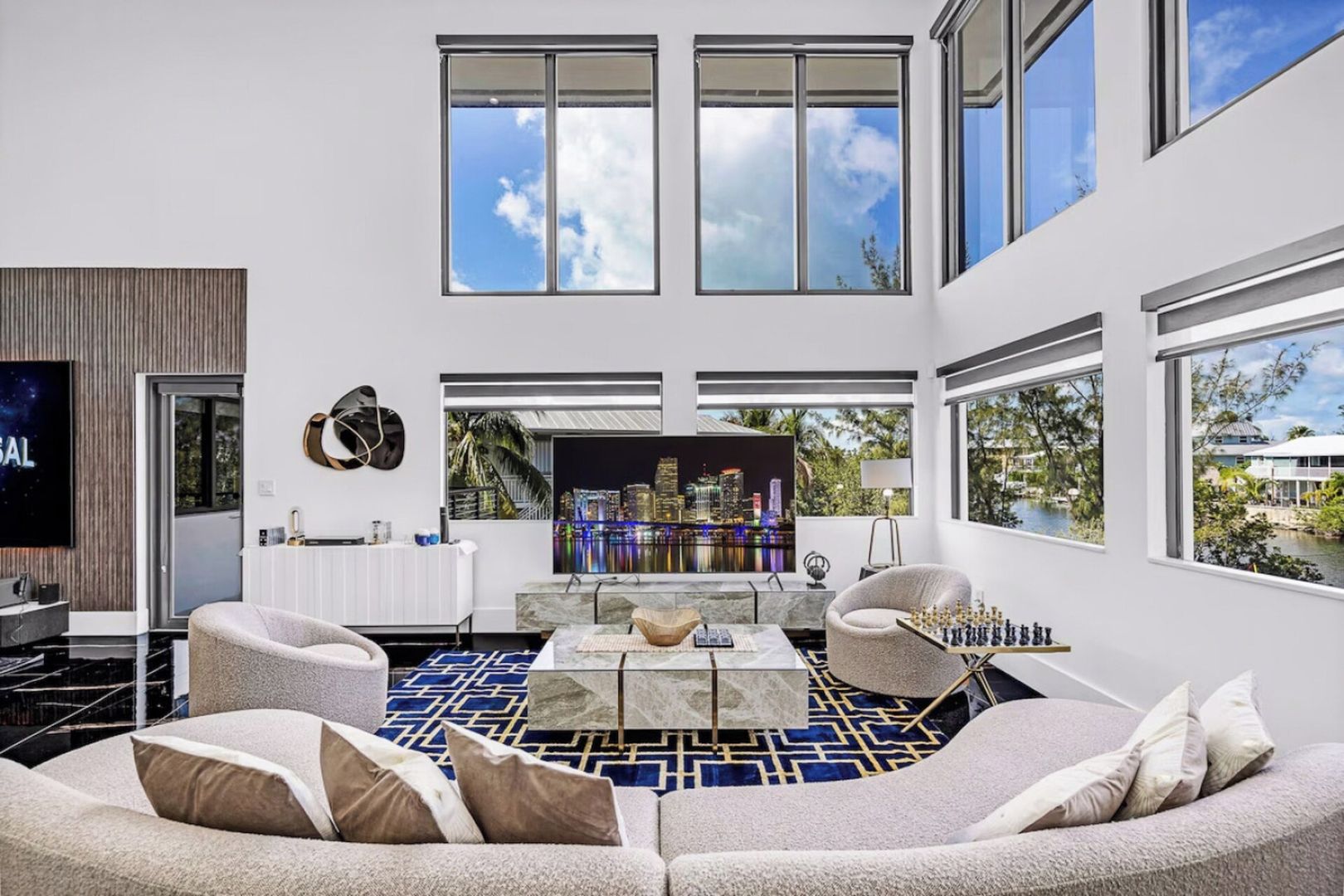 A modern living room with a sectional sofa, a coffee table, and a flat-screen TV.