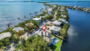 An aerial view of a coastal residential area with houses, a dock, and a marina. - Heated Pool • Hot Tub • Theater • Waterfront (Key Largo)