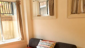 A room with a bed, a window with curtains, and a small round table. - Private Studio, Free parking, Laundry, 16 min to Downtown by city train (Toronto)