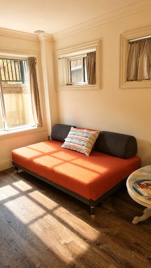 A room with a bed, a window with curtains, and a small round table.