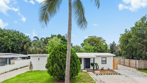 Una propiedad residencial con césped cuidado, un buzón y una casa pequeña con puerta principal y ventana.