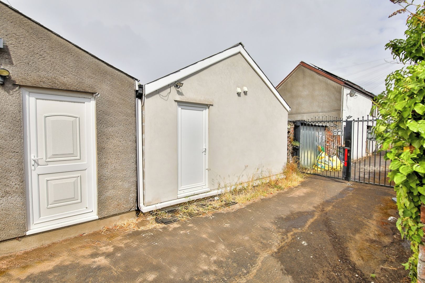 A residential property with a garage door, a white door, and a paved driveway.