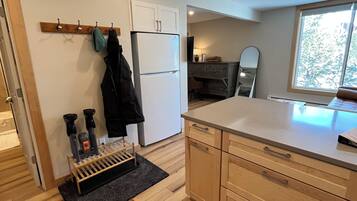 A modern kitchen with wooden cabinets, a built-in oven, and a window providing natural light.