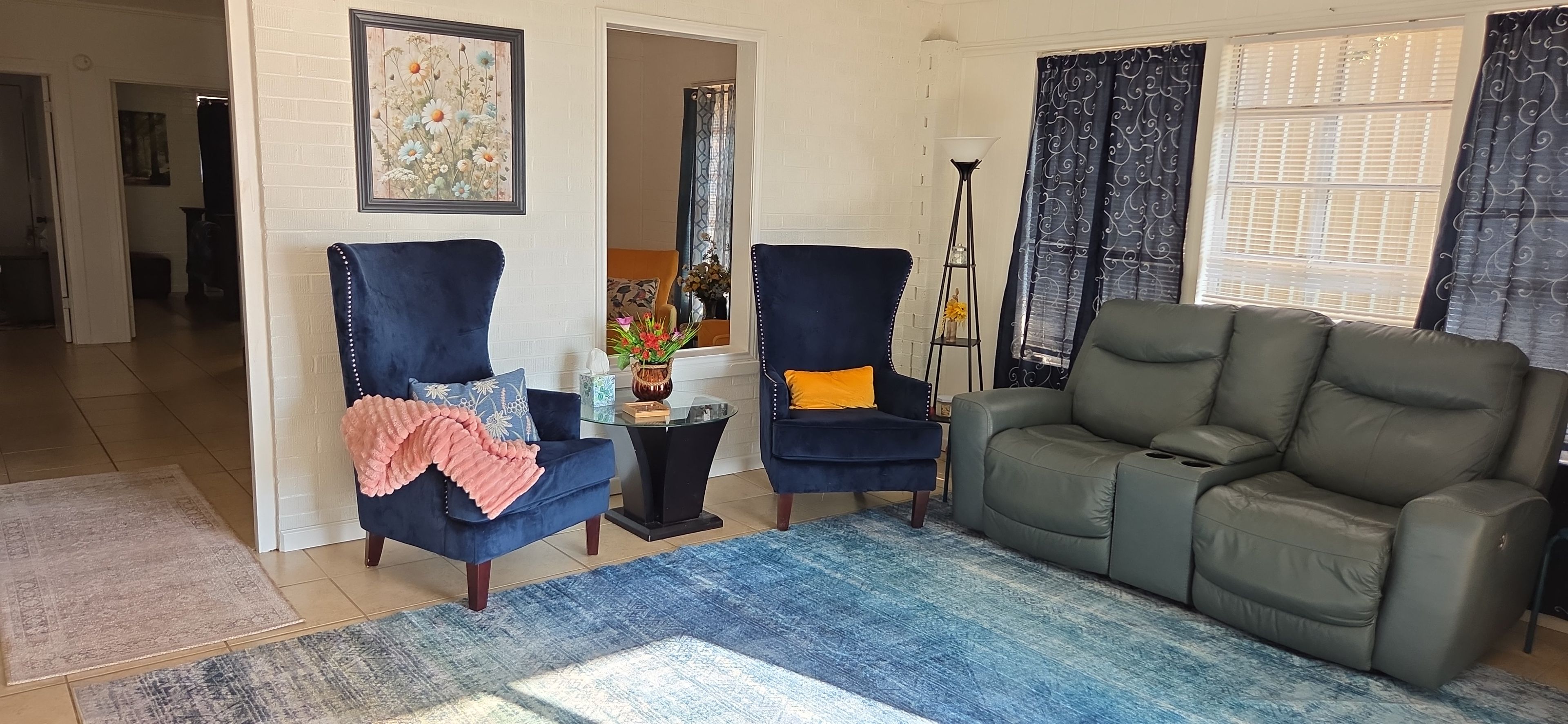 Een woonkamer met een bank, twee fauteuils, een salontafel en een vloerkleed.