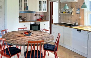 A kitchen with white cabinets, a wooden dining table, and red chairs. - Gorgeous home in Juelsminde with WiFi (Juelsminde)