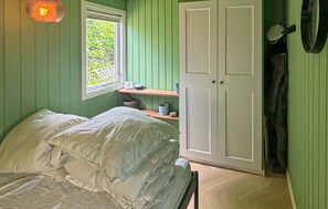 A room with a bed, a window, a door, and a shelf with items. - Gorgeous home in Juelsminde with WiFi (Juelsminde)